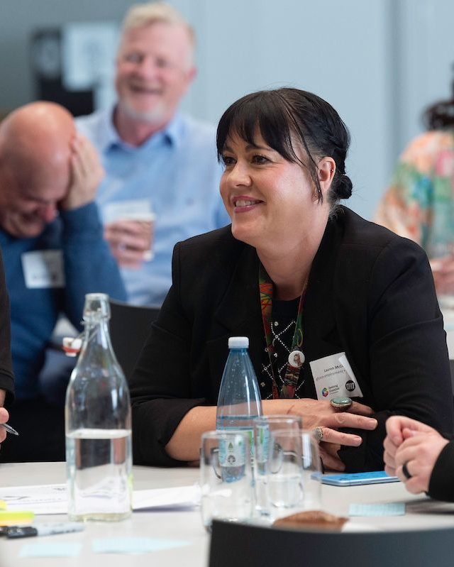 Participants listening as another table presents